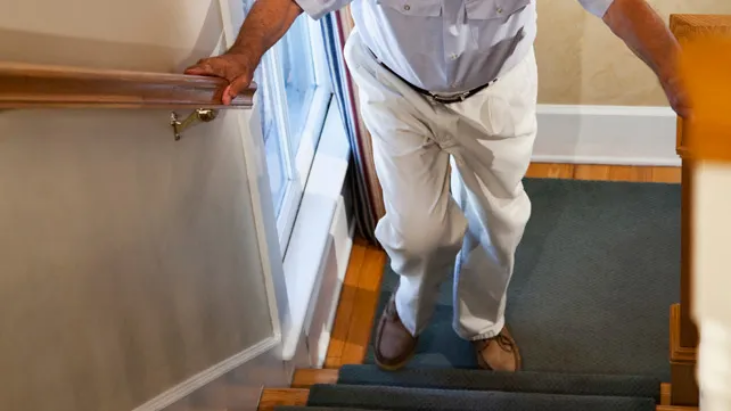 senior man having difficulty climbing the stairs